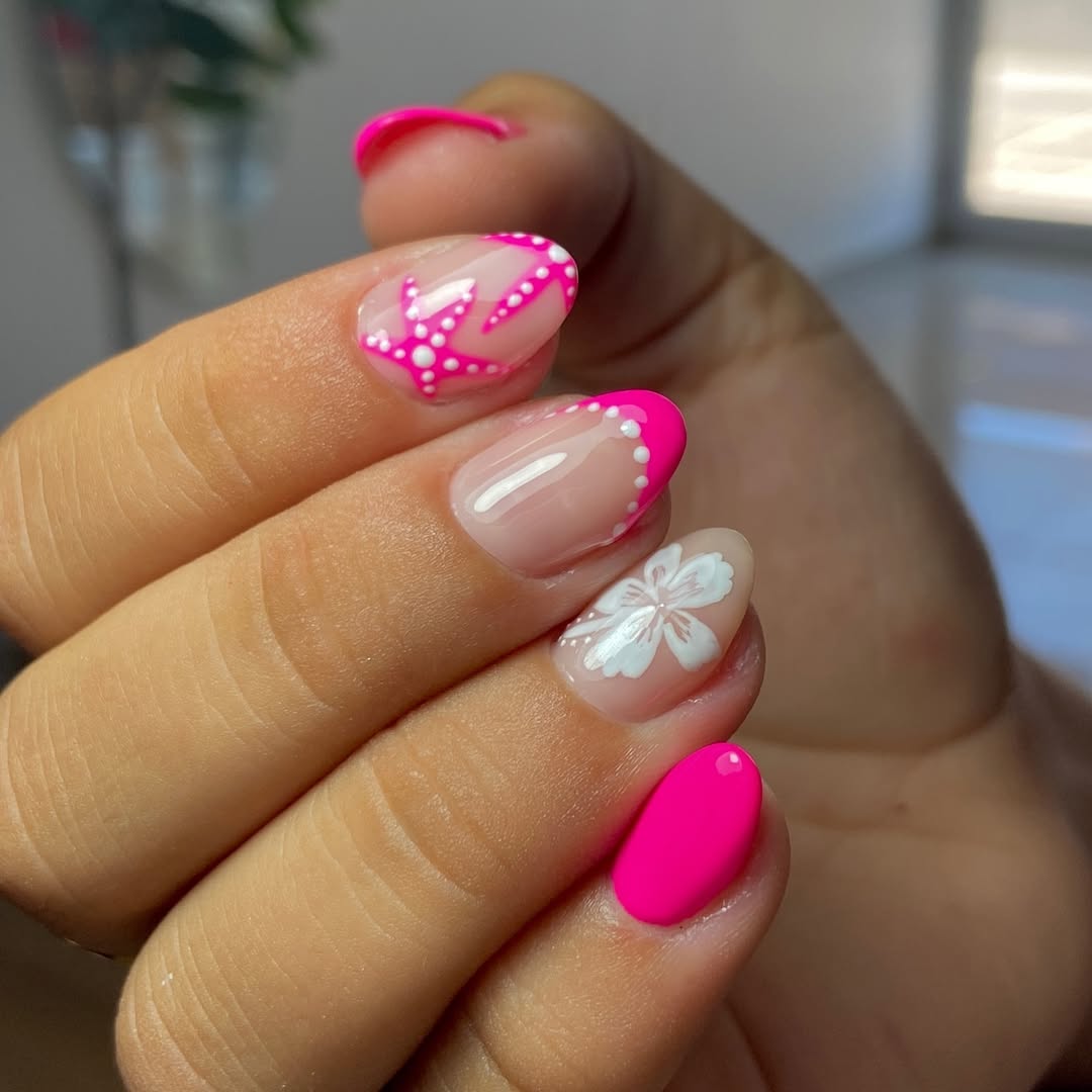 A-close-up-of-a-hand-with-bright-pink-and-nude-nail-art-with-floral-polka-dot-and-French-tip-designs.jpg