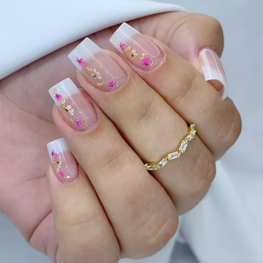 Close-up-of-a-hand-with-floral-white-french-tip-nails-and-a-ring.