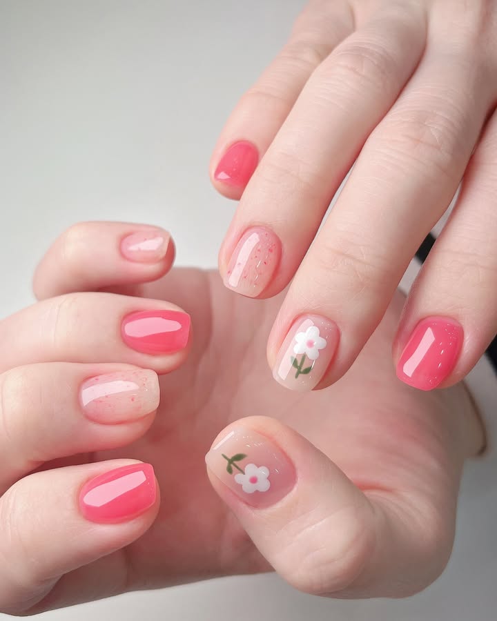 Close-up-of-hand-with-dewy-jelly-nails-featuring-confetti-like-specks-and-hand-painted-daisies-perfect-for-spring.jpg
