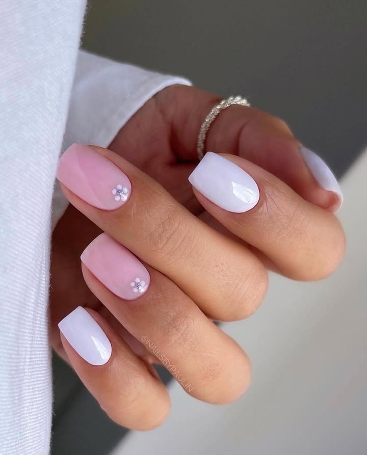 Close-up-of-hand-with-glossy-white-and-blush-jelly-nails-featuring-tiny-floral-accents-for-a-soft-fresh-spring-look.jpg