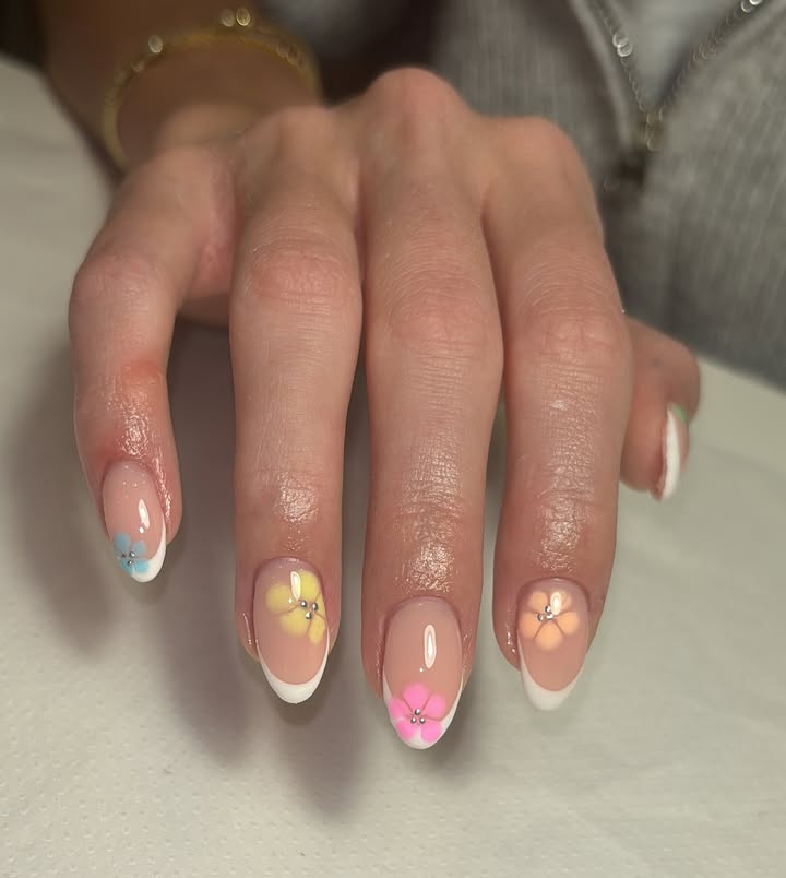 Close-up-of-hand-with-natural-base-nails-featuring-soft-pastel-3D-floral-French-tips.jpg