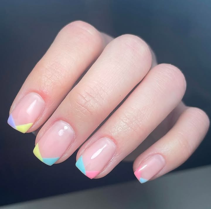 Close-up-of-hand-with-pastel-geometric-designs-on-sheer-nails-each-featuring-a-unique-color-combo.jpg