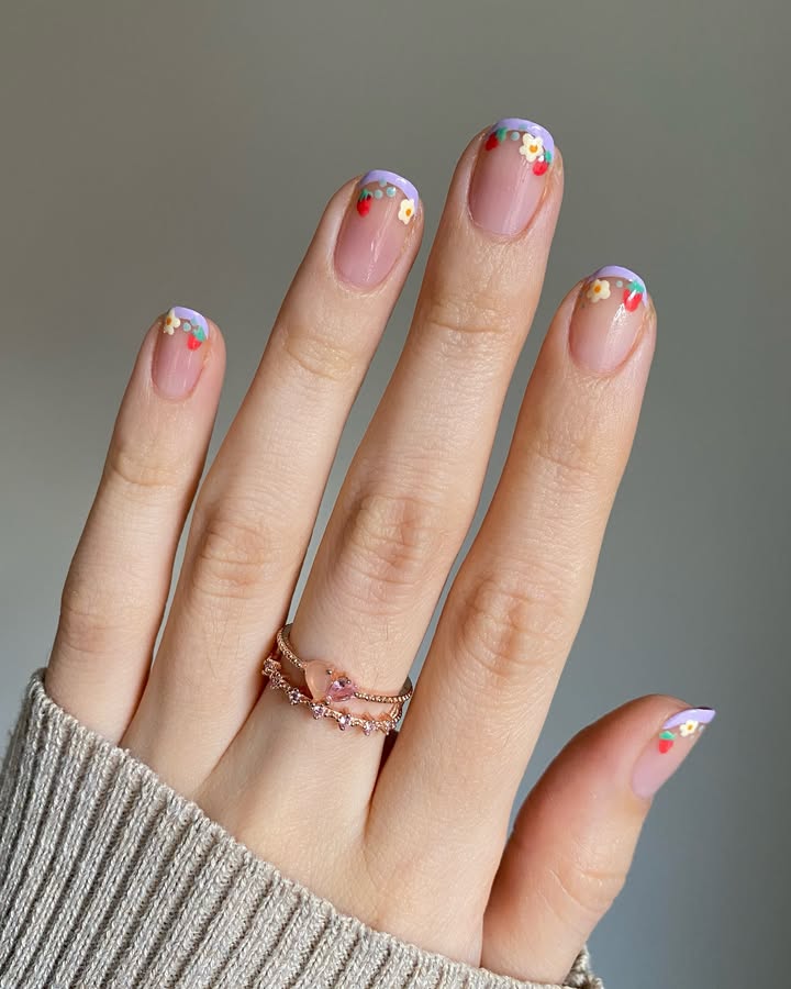 Close-up-of-hand-with-pastel-lavender-tips-tiny-strawberry-and-daisy-micro-art-paired-with-beautiful-rings.jpg