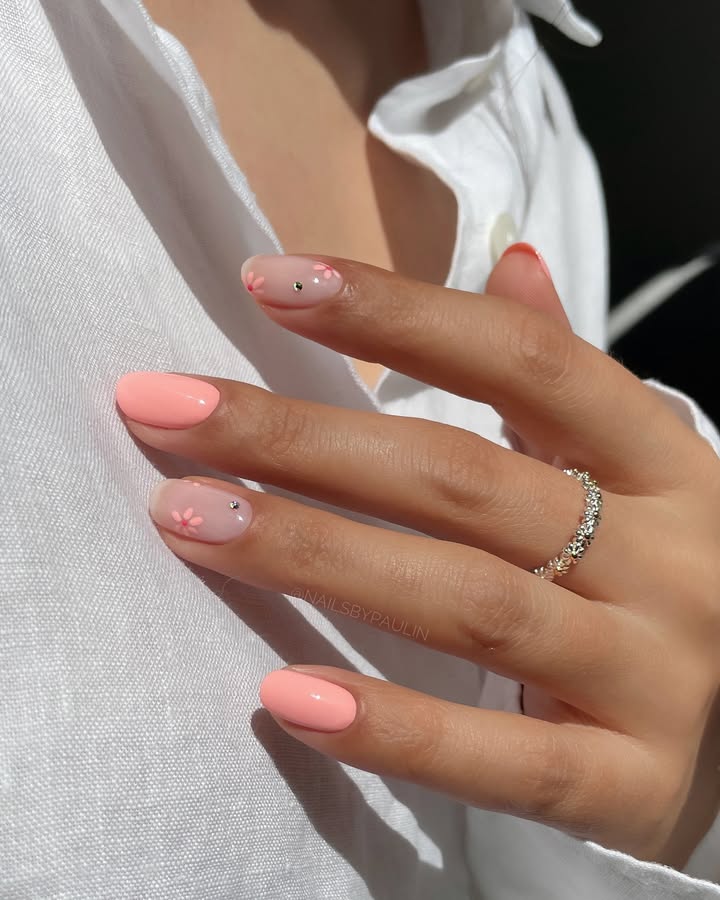 Close-up-of-hand-with-peachy-pastel-nails-featuring-sheer-accents-tiny-3D-flowers-and-subtle-rhinestones.jpg