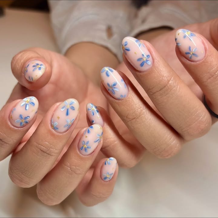 Close-up-of-hand-with-soft-blue-petal-and-gold-accent-spring-nails-giving-a-dreamy-secret-garden-vibe.jpg