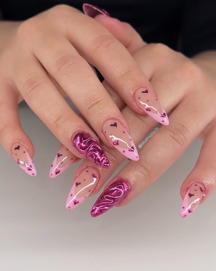 Close-up-of-hands-with-long-almond-shaped-nails-featuring-a-pink-French-tip-design-accented-with-white-swirls-and-tiny-heart-details.jpg