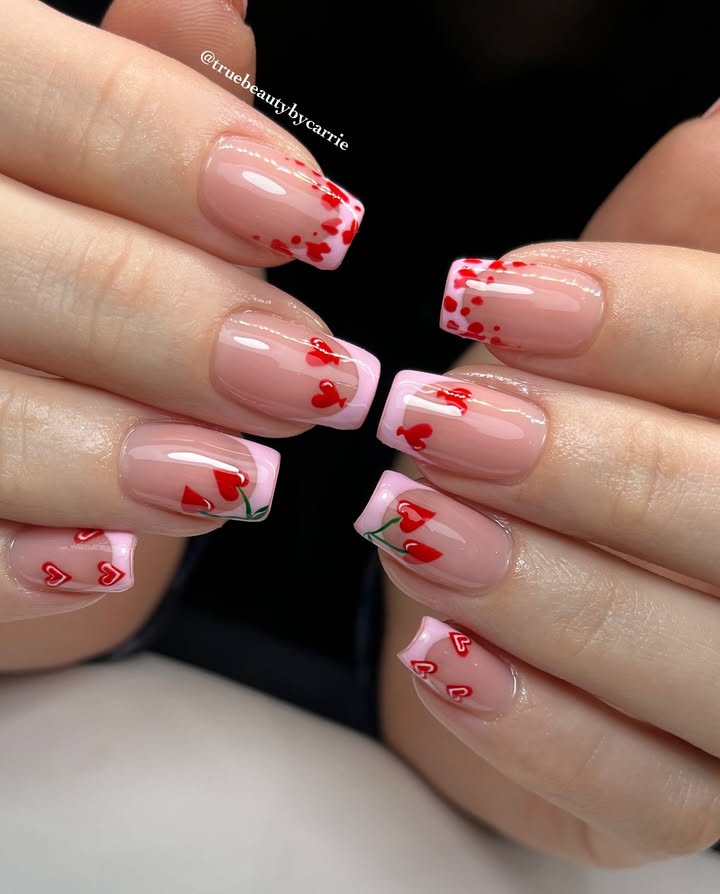 Close-up-of-pink- french-tip-nails-decorated-with-red-cherries-tiny-hearts-green-stems-and-confetti-accents-1.jpg