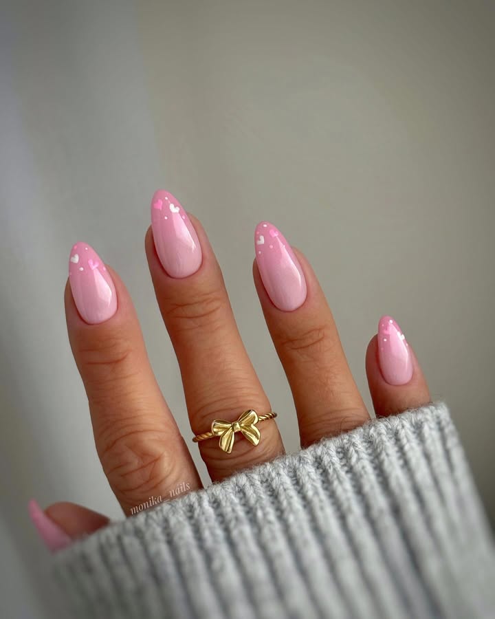 Hand-with-pink-almond-nails-white-heart-accents-gold-bow-ring-and-grey-sweater-sleeve.__.jpg