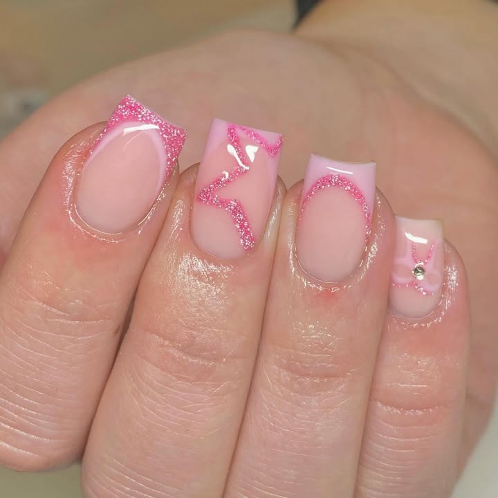 Hands-with-a-glittery-French-manicure-in-nude-pink-glossy-finish-delicate-blooms-and-LOVE-accents.jpg