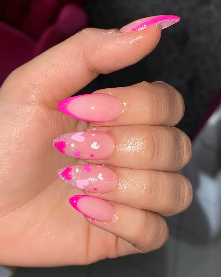 Hands-with-bold-pink-French-tips-bordered-with-hearts-and-a-glossy-glitter-topcoat.jpg