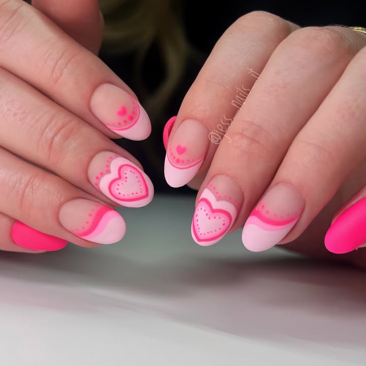 Hands-with-layered-love-nail-art-in-rosy-pink-featuring-heart-motifs-delicate-dots-and-a-mix-of-matte-and-glossy-finishes.jpg