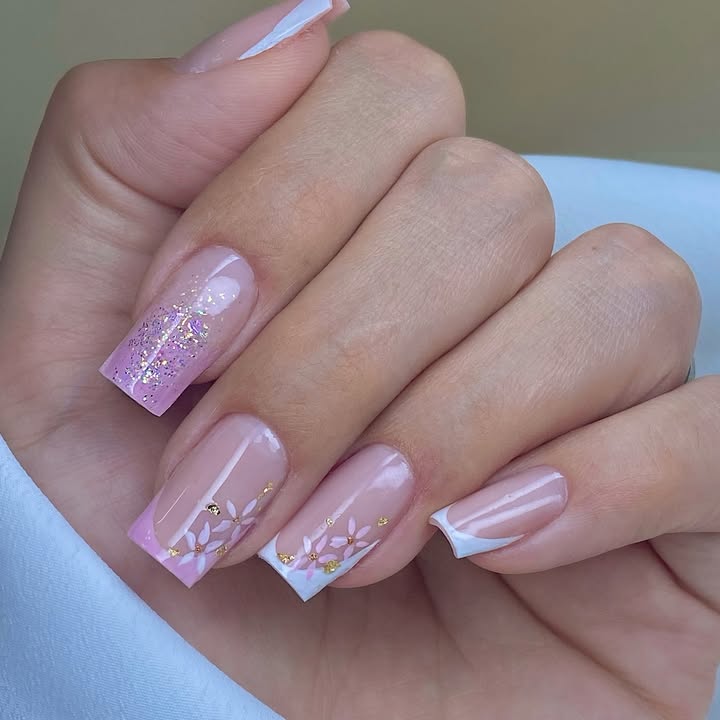 Hands-with-pastel-pink-French-tips- nails-odorned-with-a-soft-pink-to-white-ombre-glitter-white-florals-and-gold-accents.jpg