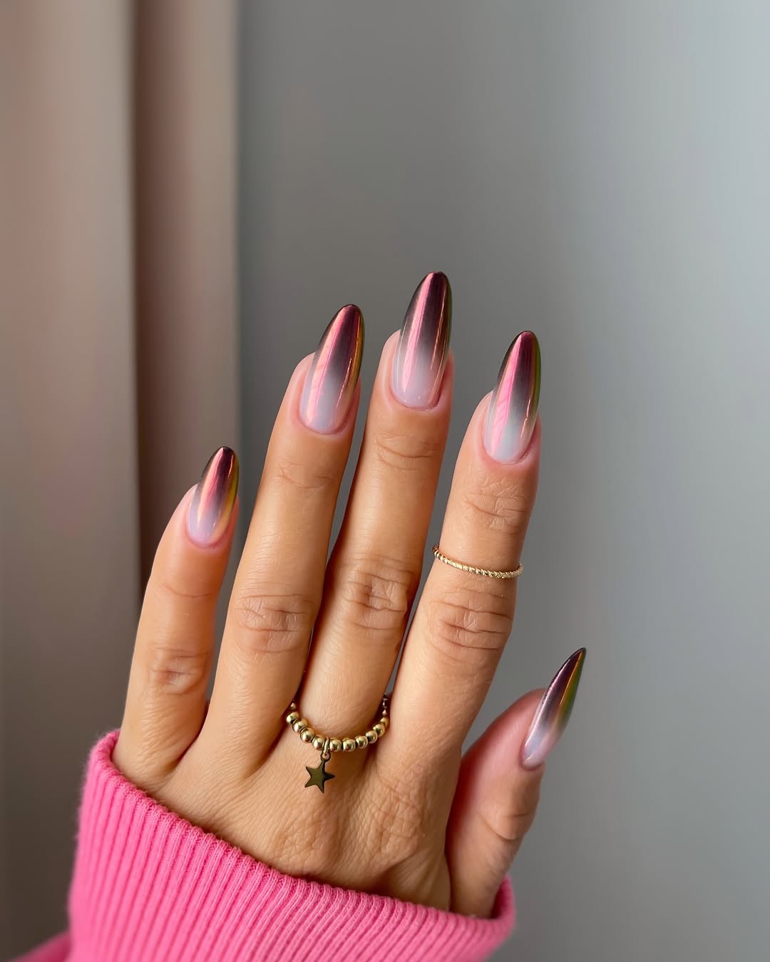 Metallic-ombre-manicure-with-a-shimmering-chrome-finish-blending-pink-gold-and-bronze-tones-in-a-gradient-design-paired-with-Ring-and-pink-sweater.jpg
