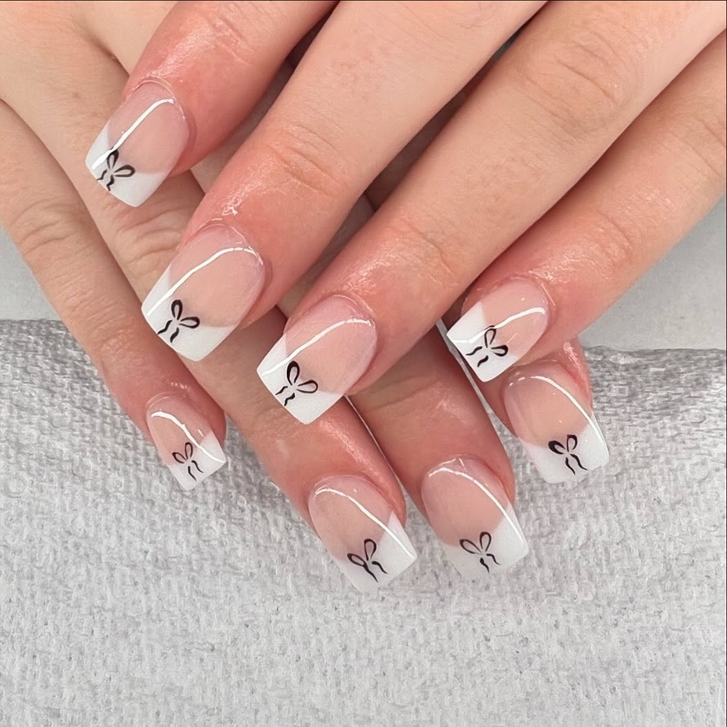 Parisian-bow-white-french-tip-nails-with-rhinestone-accents.