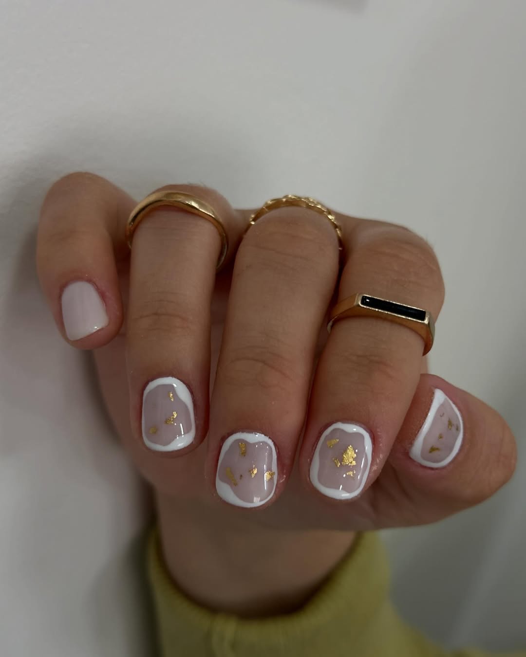 Short-nails-with-white-borders-and-gold-foil-accents.