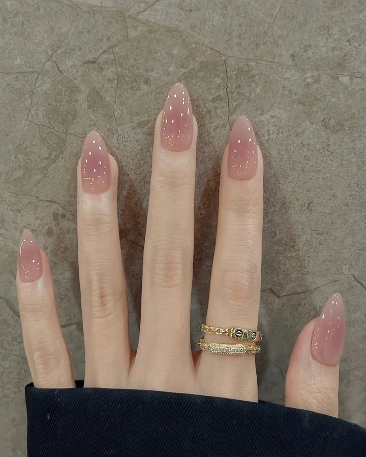 Starry-Blush-Ombre-manicure-with-a-blush-toned-semi-opaque-base-paired-with-stylish-rings-and-a-black-shirt.jpg