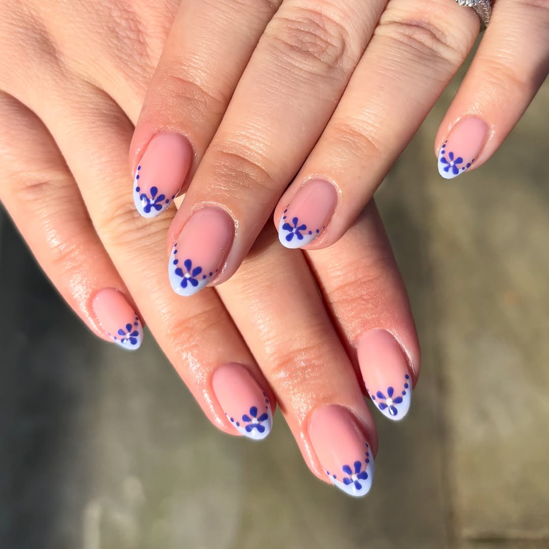Blue-daisy-dip-May-nails-with-rose-base-white-tips-and-deep-blue-floral-accents.jpg