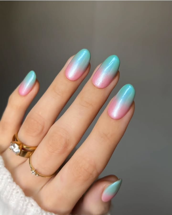 Close-up-of-glossy-pink-to-aqua-gradient-nails-with-a-pearl-kissed-finish-and-chrome-powder-over-gel-polish.jpg