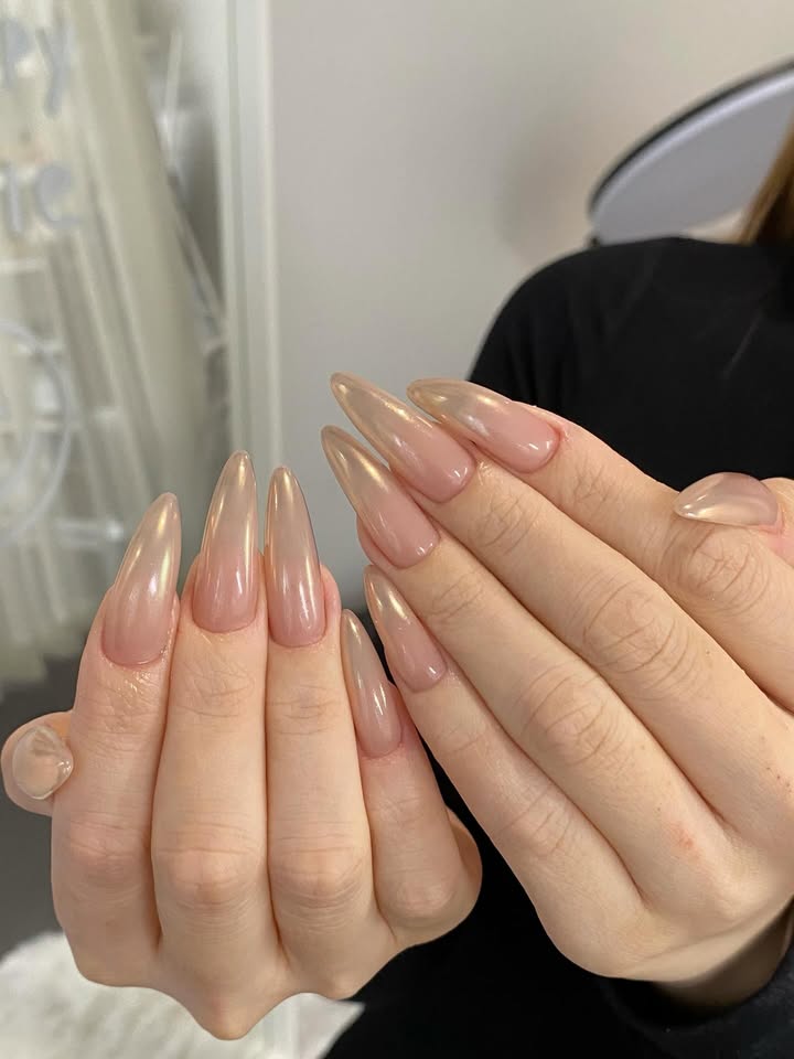 Close-up-of-sleek-stiletto-shaped-nails-with-a-stunning-golden-glaze-and-molten-gilded-glass-finish.jpg