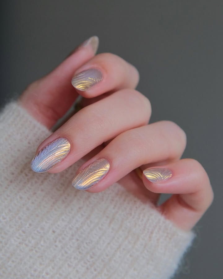 Golden-haze-chrome-nails-with-metallic-ripples-and-a-high-shine-iridescent-finish-paired-with-white-outfit.jpg