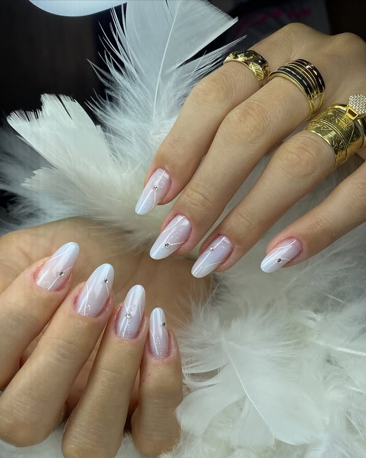 Milky-white-nails-with-frosted-base-delicate-swirls-and-subtle-crystals-for-a-soft-glam-look.jpg