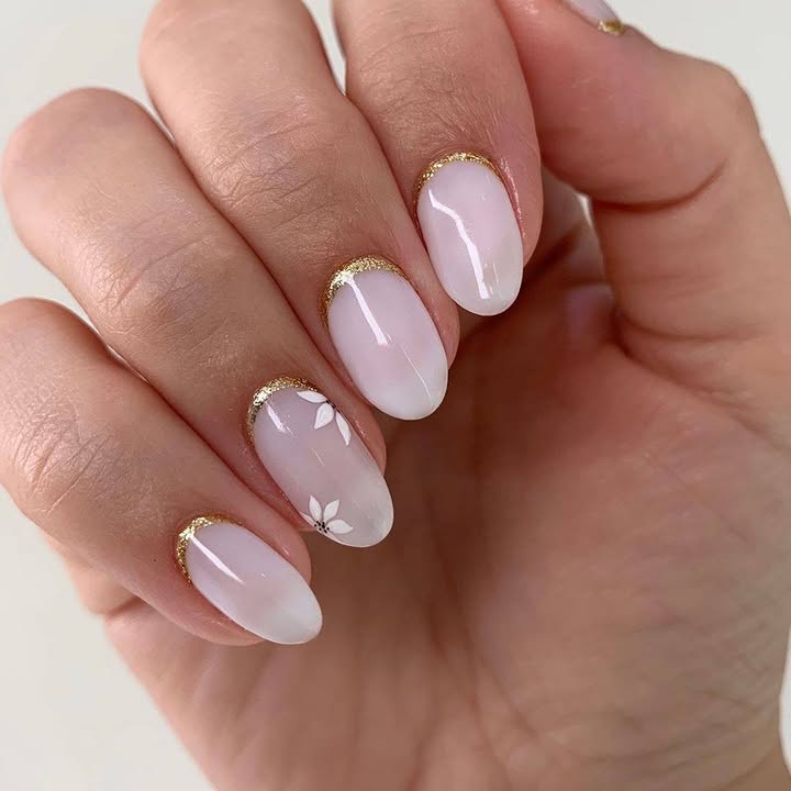 Milky-white-nails-with-soft-gold-cuticle-lines-and-dainty-white-petal-accents.jpg