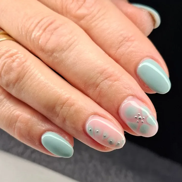 Mint-green-nails-with-florals-and-silver-studs-perfect-for-spring-nail-designs.webp