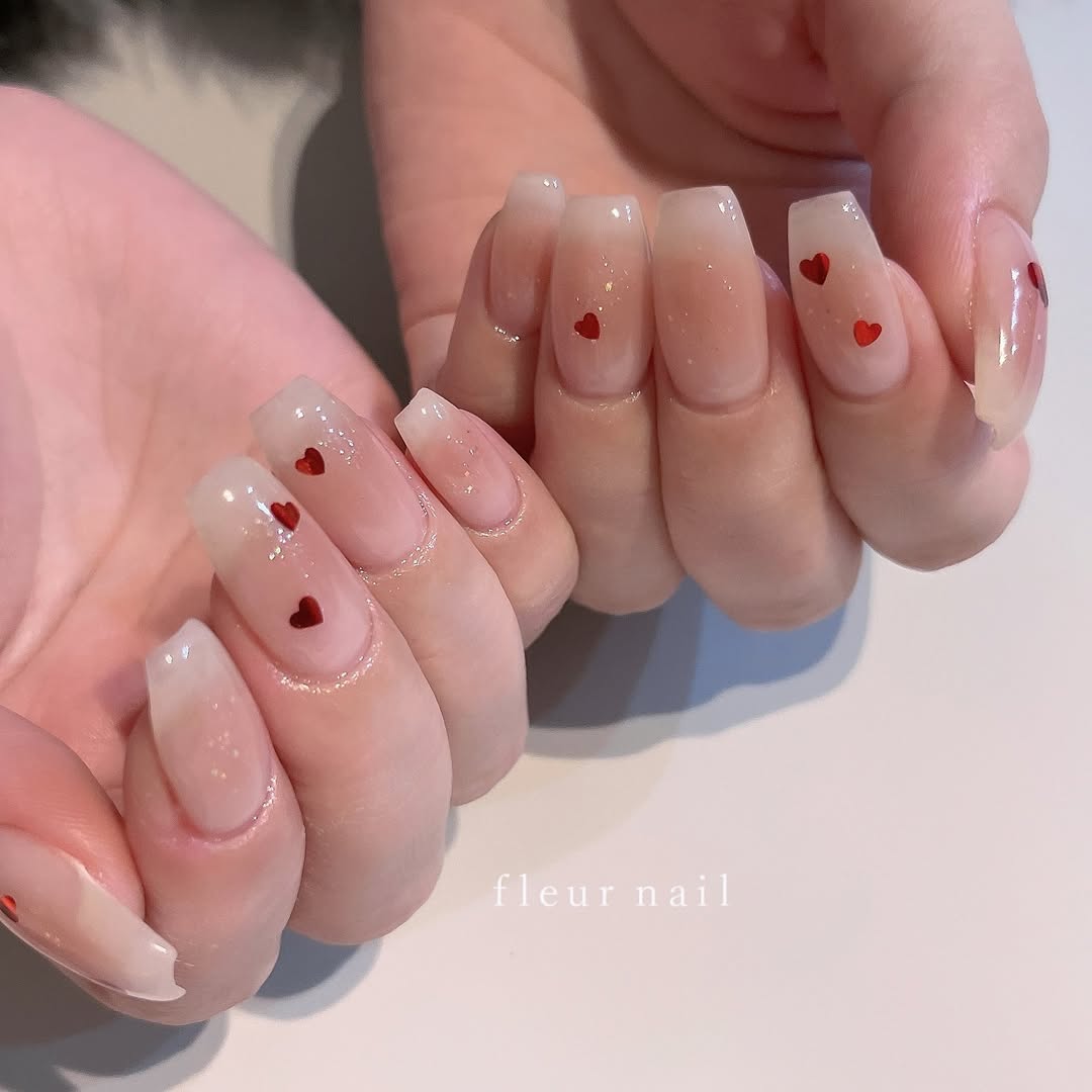 Square-nails-with-a-sheer-milky-white-base-and-tiny-red-hearts.jpg